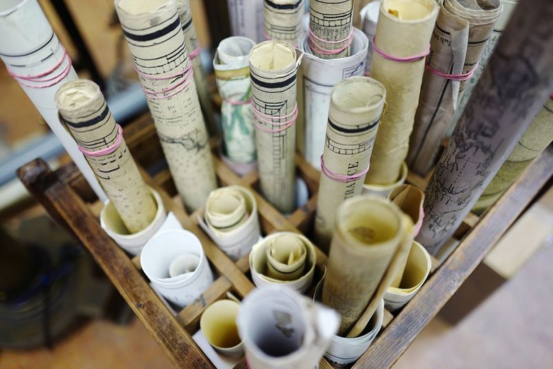 High angle view of old rolled maps in wooden box