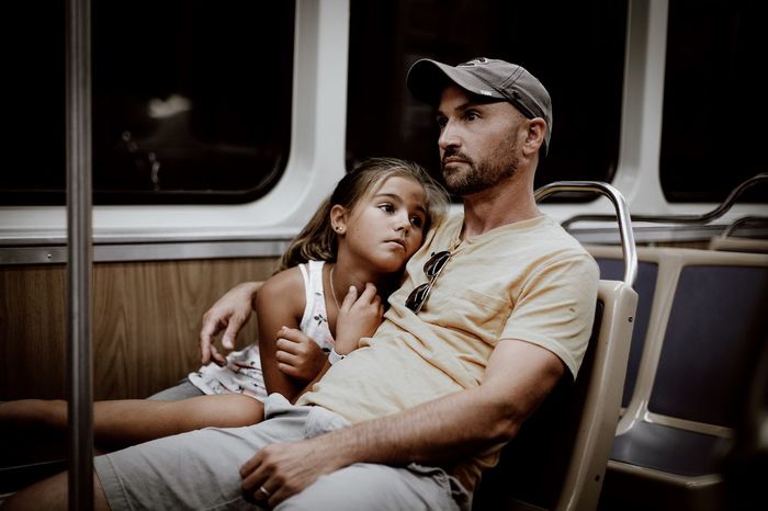 Man sitting with daughter in train
