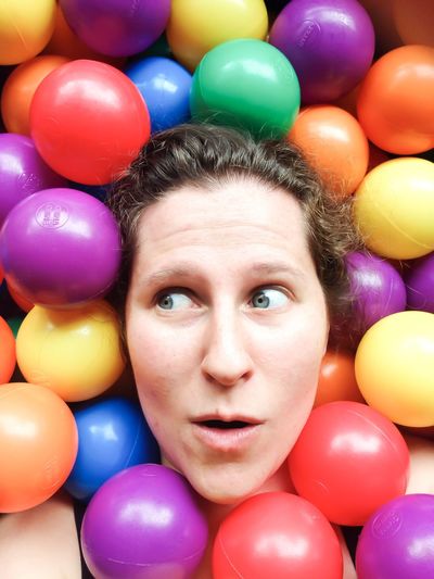Woman looking away by colorful balls