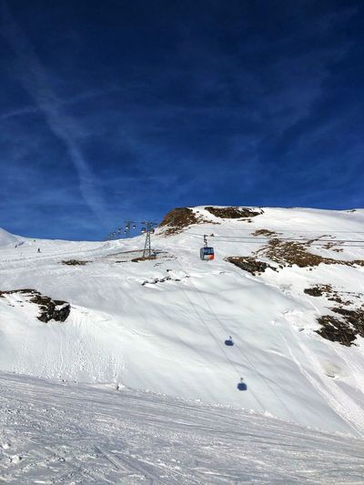 Scenic view of snowcapped mountains against blue sky