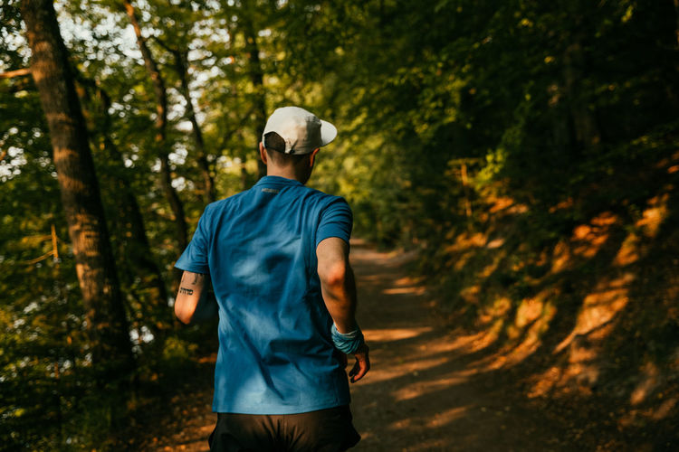 Rear view of man running amidst plants