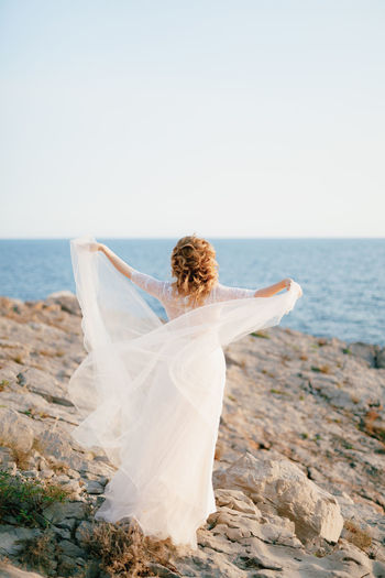 Woman at beach against sky
