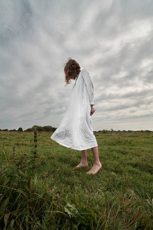 Woman standing on field against sky