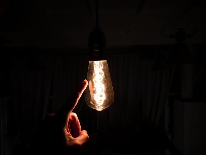 Person holding illuminated light bulb