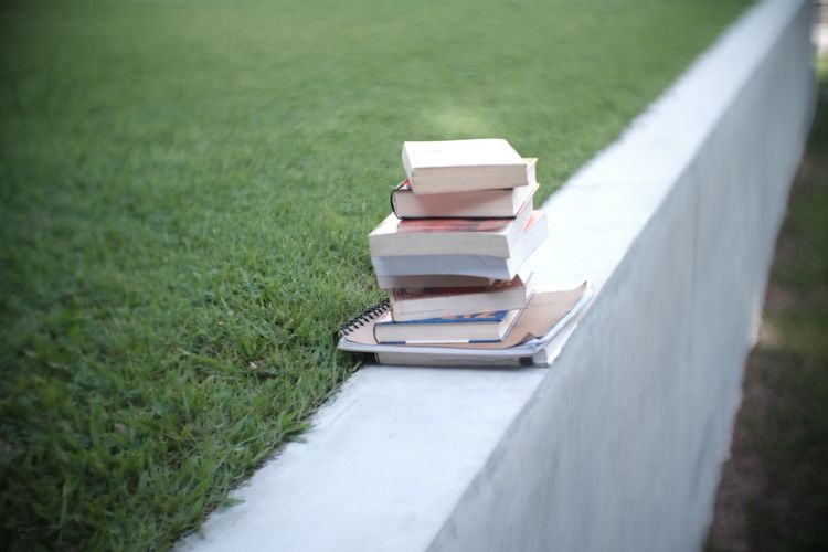 Books stacked on retaining wall