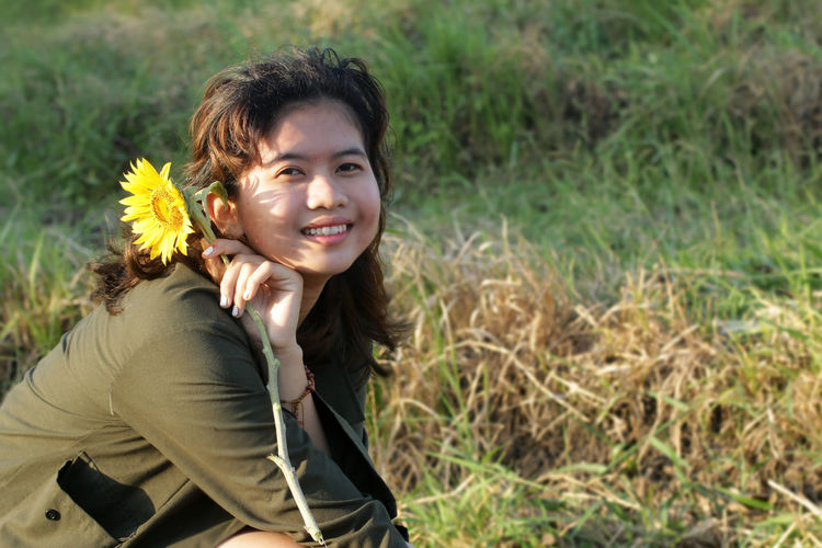 Portrait of a smiling young woman lying on land