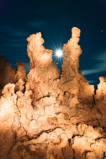 Low angle view of illuminated rock formation against sky at night