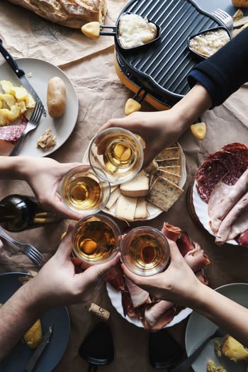 Cropped image of people toasting wineglass at table