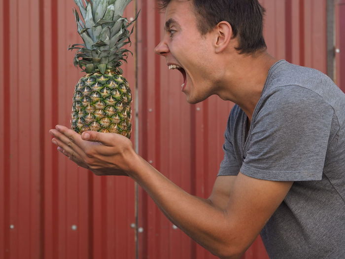 Frustrated man holding pineapple