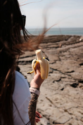 Midsection of woman holding banana