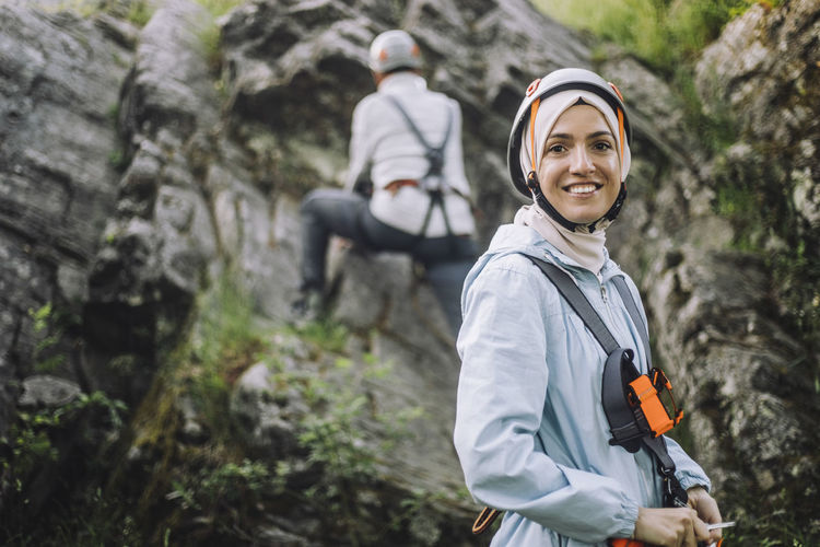 Portrait of smiling woman wearing helmet during rock climbing