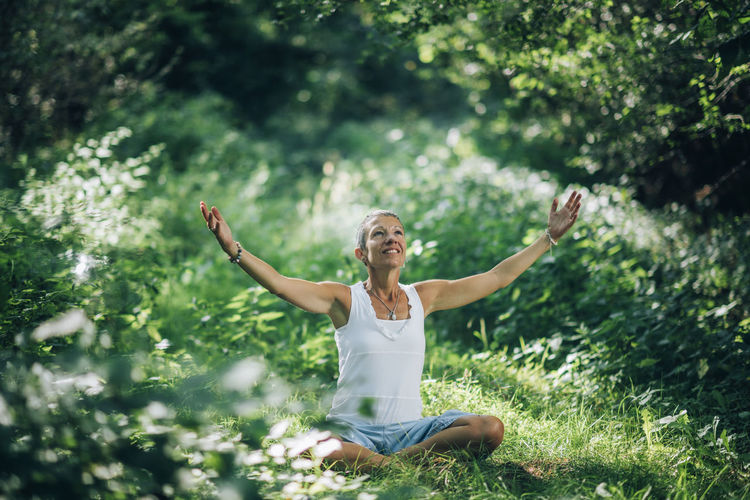 Awareness meditation. mindful woman sitting on the ground with open arms