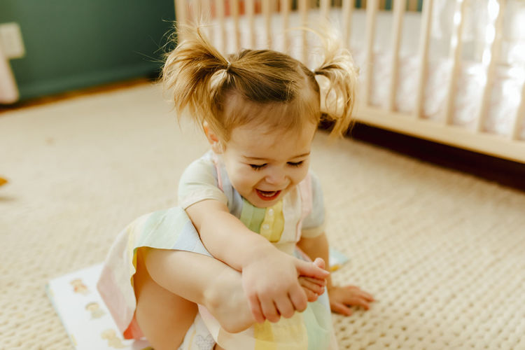 Toddler girl playing with her feet
