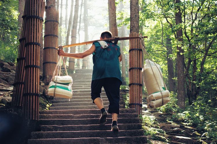 Full length of man carrying sacks on steps