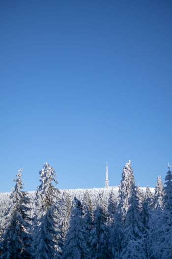 Low angle view of snowcapped mountain against clear blue sky