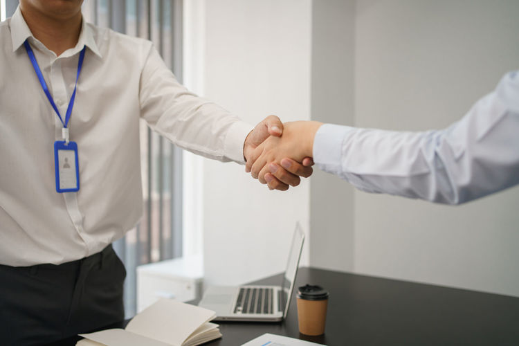 Midsection of businessman shaking hands