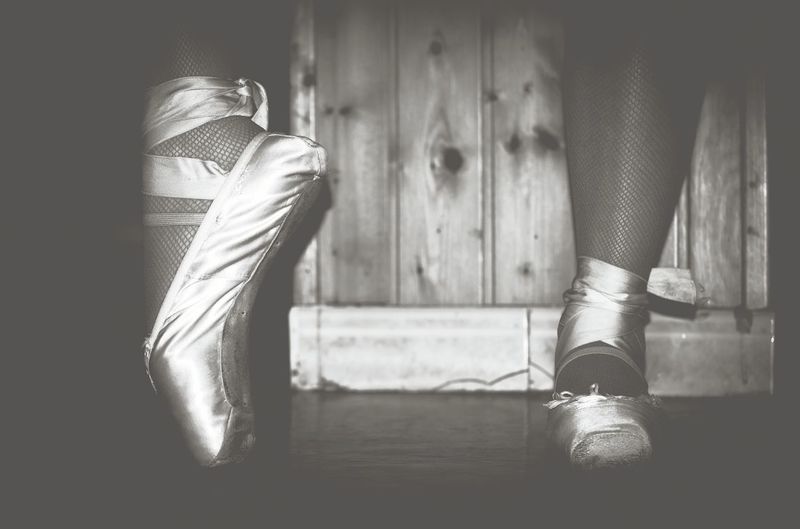 Low section of ballet dancer tiptoeing on floor