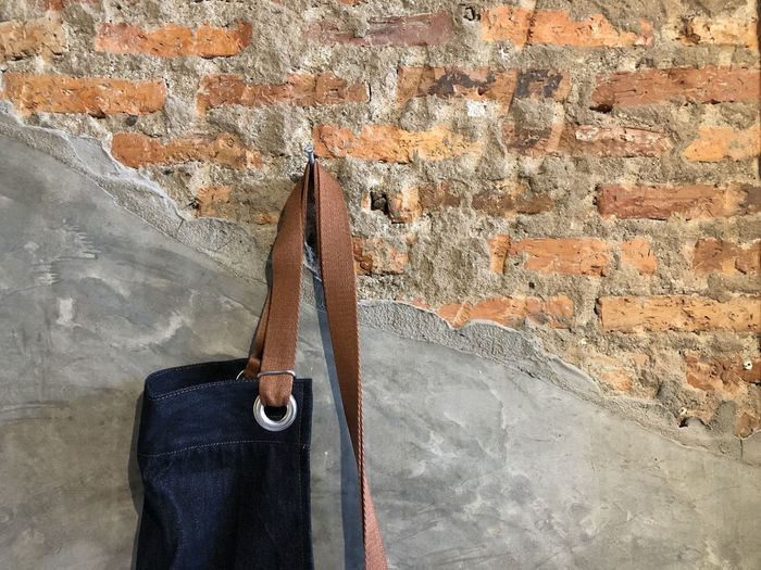 Close-up of apron clothes hanging on old brick wall