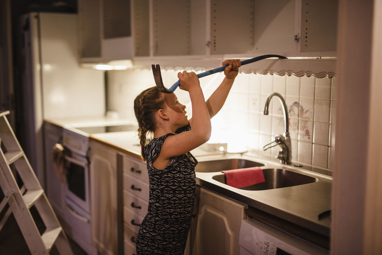 Girl dismantling kitchen cupboards