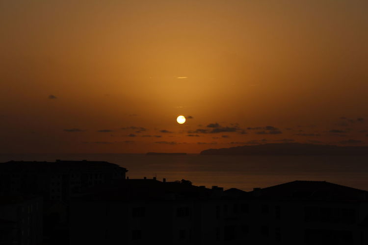 Scenic view of sea against orange sky