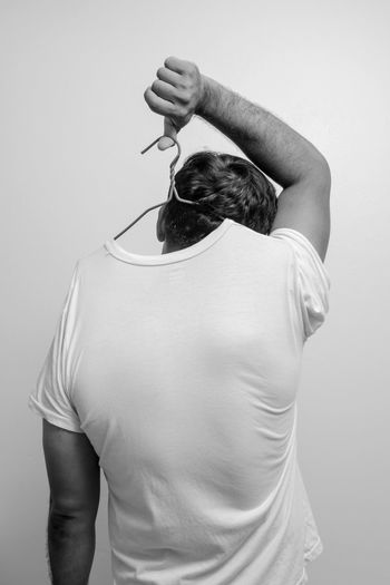 Midsection of man holding camera over white background