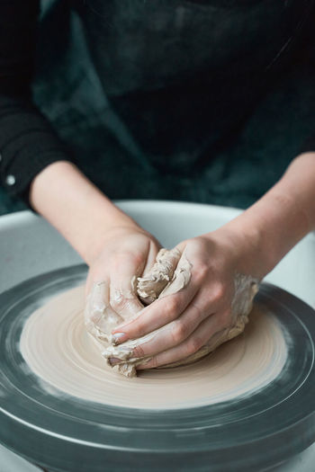Midsection of woman making pottery