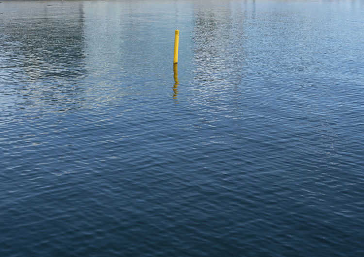 High angle view of yellow buoy in water in sea