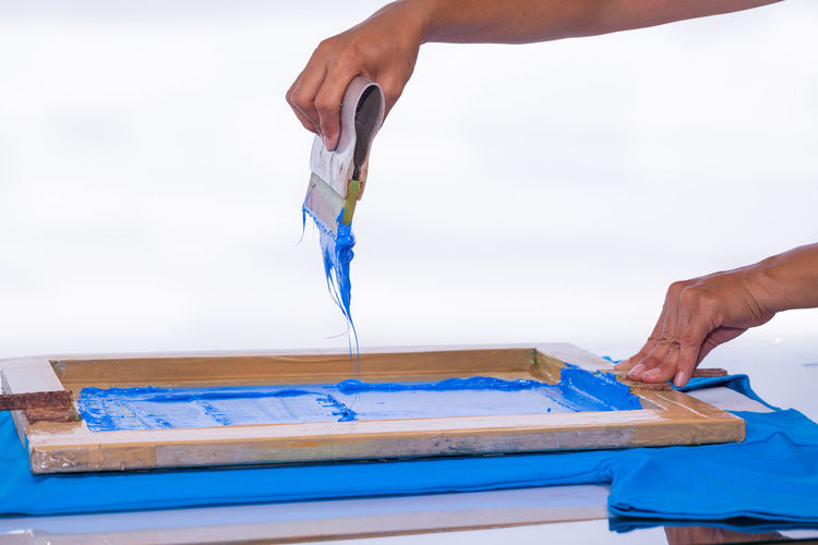 Cropped image of person screen printing against white background