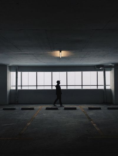 Side view of silhouette man walking in corridor