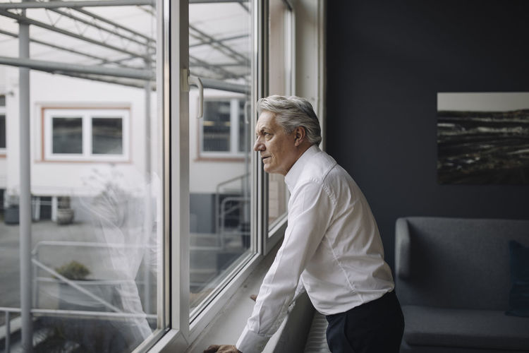Senior businessman looking out of the window