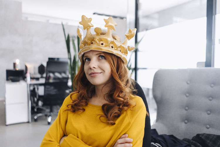 Businesswoman in office wearing a crown