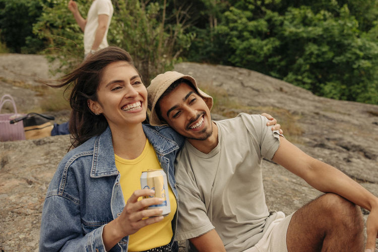 Side view of friends sitting on field