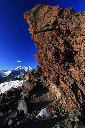 Scenic view of snowcapped mountains against blue sky