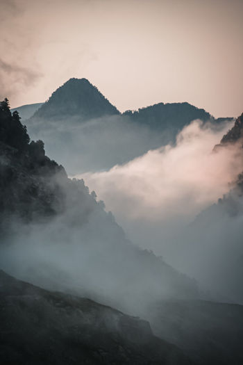 Scenic view of mountains against sky in foggy weather