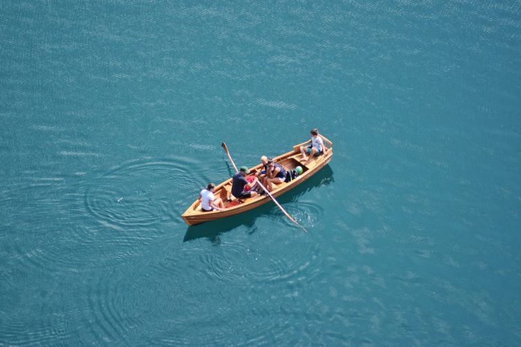 Aerial view of people sailing in boat at lake