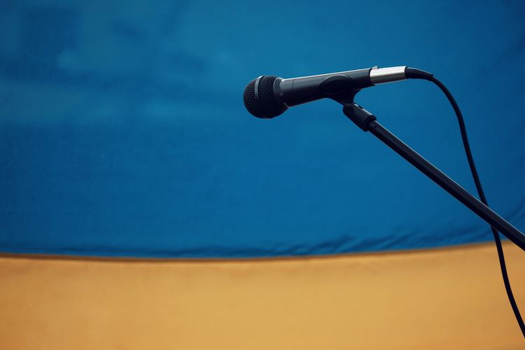 Close-up of microphone against yellow wall