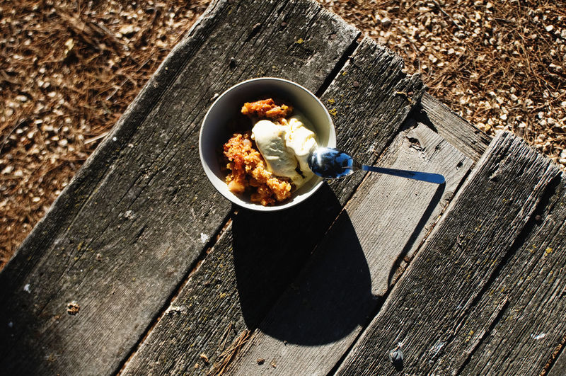 High angle view of apple crumble with ice cream on table