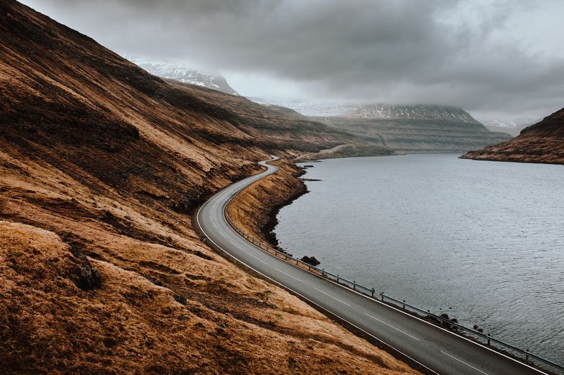 Scenic view of road by mountains against sky