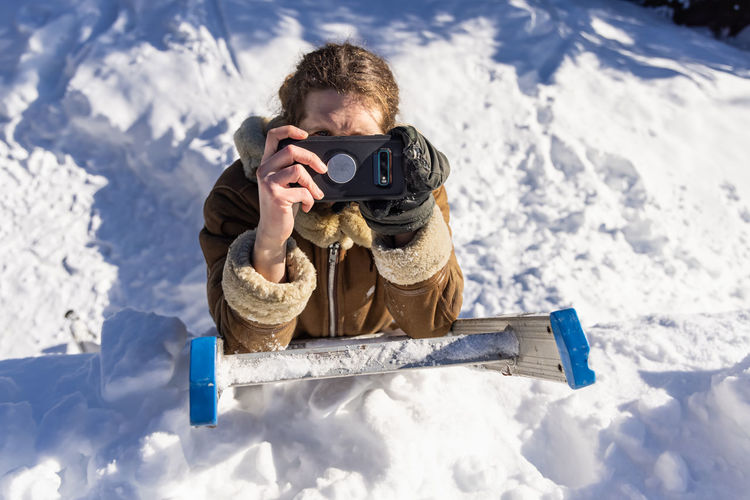Man photographing on snow covered camera