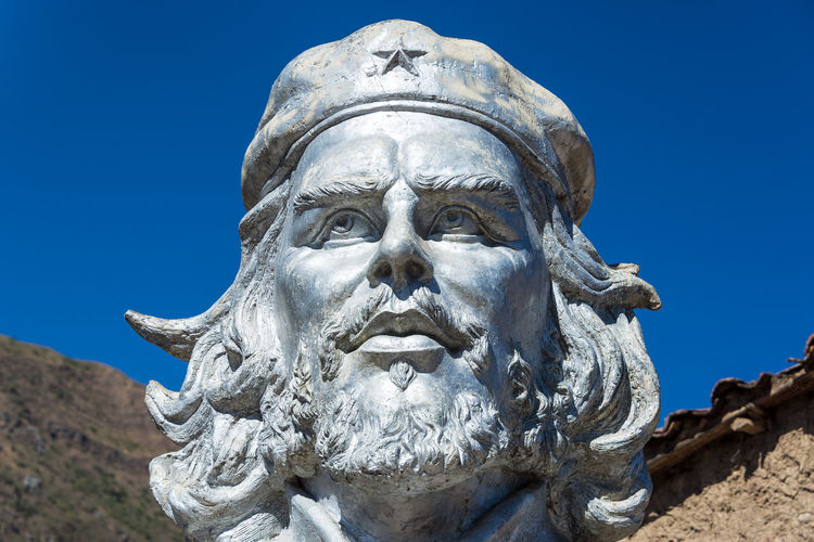 Close-up of che guevara statue against blue sky