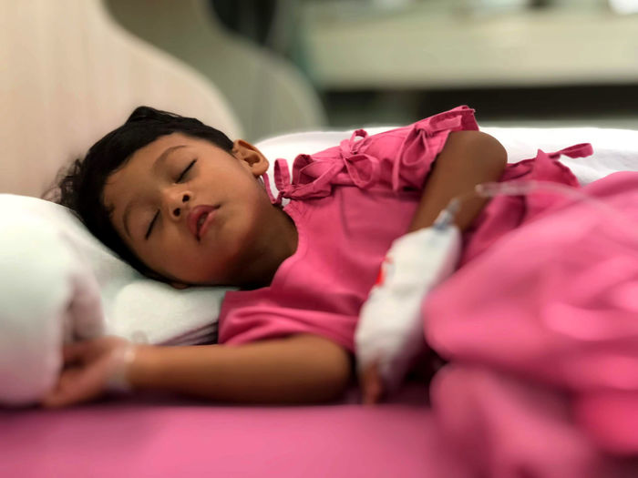 Girl sleeping on bed in hospital