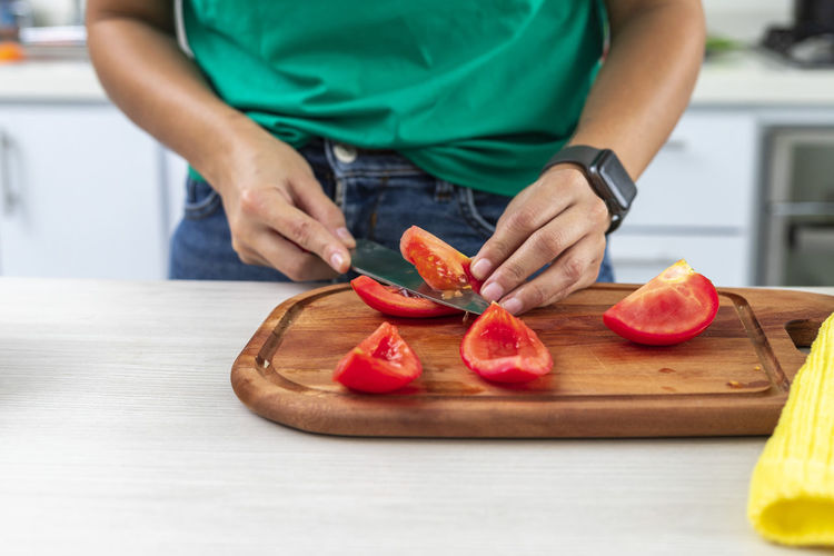 Midsection of person preparing food on cutting board at home