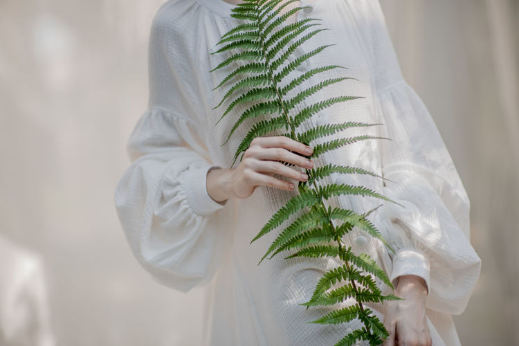 Midsection of woman holding plant