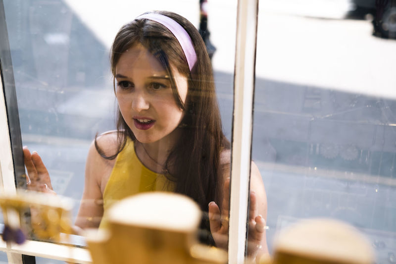 Woman with long hair looking in store window