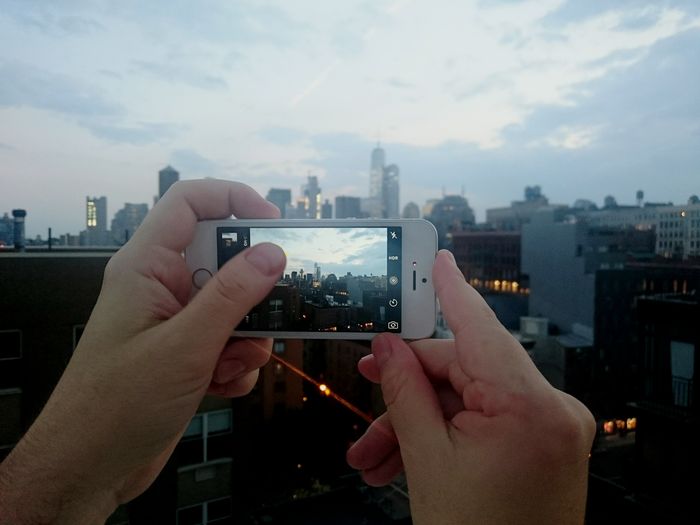 Cropped image of man photographing through smart phone