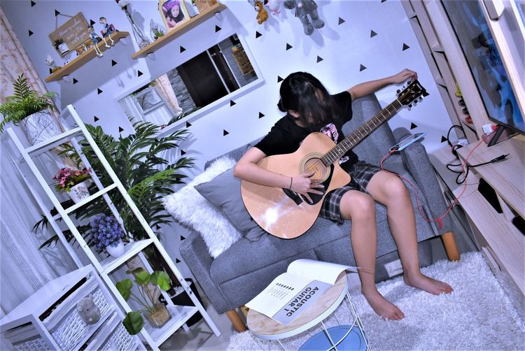 High angle view of woman playing guitar