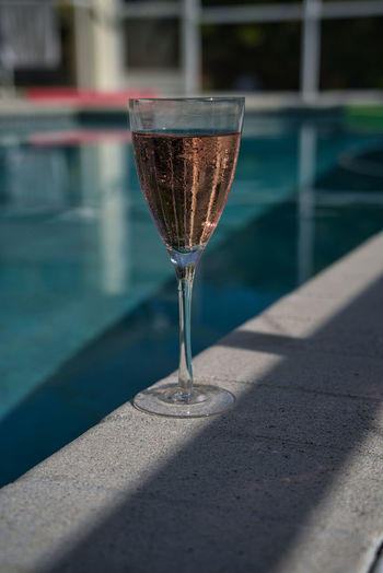 Close-up of wine champagne glass on pool