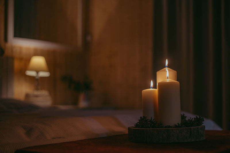 Close-up of illuminated candles on table at home