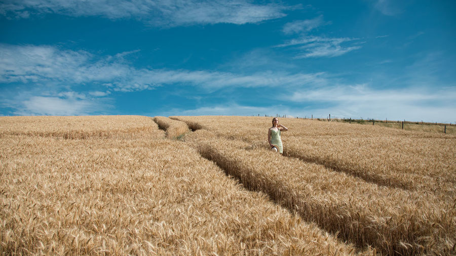 Rear view of man standing on field against sky