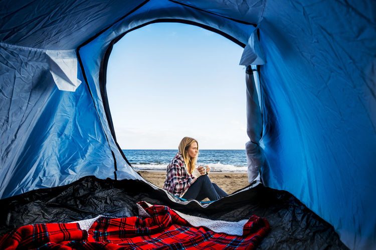 beautiful young girl camping on sand beach front to the ocean in Tenerife island Alone Freedom Adult Adventure Beach Campinglife Day Full Length Getting Away From It All Horizon Over Water Nature Ocean One Person One Woman Only Outdoors People Sea Sitting Sky Tenerife Island Tent Travel Vacations Women Young Adult